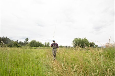 Fisherman with fishing rod on grass field, Clark Fork, Montana and Idaho, US Foto de stock - Sin royalties Premium, Código: 614-08991298