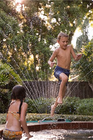 preteen sister swimsuit - Young boy jumping into garden pool, mid-air Photographie de stock - Premium Libres de Droits, Code: 614-09017192