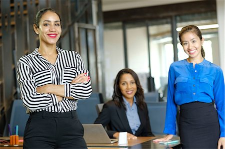 simsearch:614-06442777,k - Portrait of three businesswomen in open plan office, smiling Stock Photo - Premium Royalty-Free, Code: 614-09017211