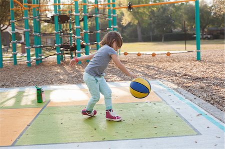 Girl bouncing basketball in playground Stock Photo - Premium Royalty-Free, Code: 614-09017371