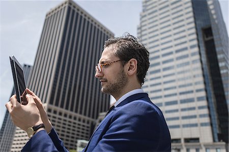 simsearch:614-09017489,k - Young businessman looking at digital tablet by New York skyscrapers, USA Photographie de stock - Premium Libres de Droits, Code: 614-09017495