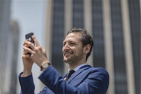 simsearch:614-09017489,k - Smiling young businessman taking selfie outside office building, New York, USA Photographie de stock - Premium Libres de Droits, Code: 614-09017501