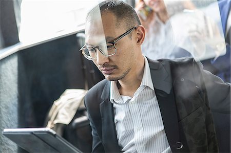 simsearch:614-09258544,k - Businessman looking at digital tablet on passenger ferry Photographie de stock - Premium Libres de Droits, Code: 614-09017516