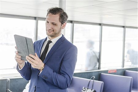 simsearch:614-08926442,k - Young businessman looking at digital tablet on passenger ferry Stock Photo - Premium Royalty-Free, Code: 614-09017511