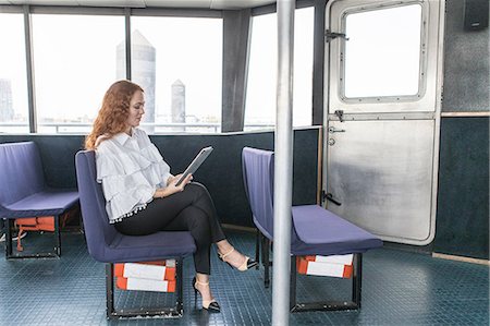 simsearch:614-09017489,k - Stylish young businesswoman looking at digital tablet on passenger ferry Photographie de stock - Premium Libres de Droits, Code: 614-09017520