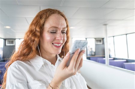 simsearch:649-09061459,k - Smiling young businesswoman looking at smartphone on passenger ferry Photographie de stock - Premium Libres de Droits, Code: 614-09017523