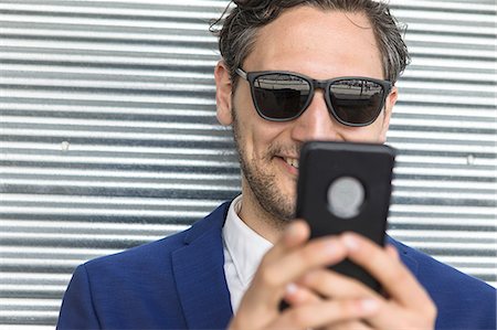 simsearch:614-08827243,k - Young businessman in sunglasses looking at smartphone Stock Photo - Premium Royalty-Free, Code: 614-09017544