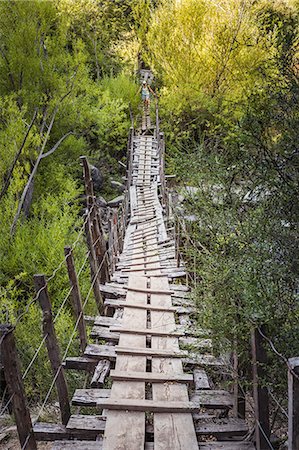 Female hiker crossing dangerous wooden footbridge at Cajon del Azul near El Bolson, Patagonia, Argentina Foto de stock - Sin royalties Premium, Código: 614-09017673