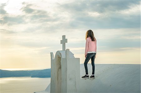 dangerous - Girl standing on top of church, O'a, Santorini, Kikladhes, Greece Stock Photo - Premium Royalty-Free, Code: 614-09017798