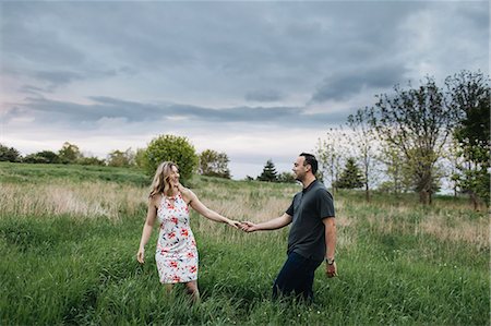 simsearch:614-09213916,k - Romantic couple holding hands in field Stock Photo - Premium Royalty-Free, Code: 614-09026475