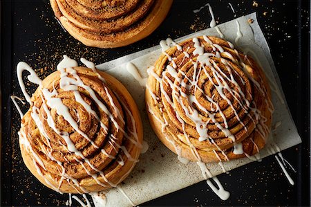 Cinnamon Rolls drizzled with Icing on wax paper Stock Photo - Premium Royalty-Free, Code: 614-09026631