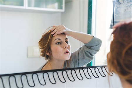 simsearch:614-06402825,k - Reflection of young woman with hand on forehead looking at bathroom mirror Foto de stock - Royalty Free Premium, Número: 614-09026669