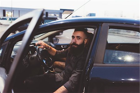 simsearch:851-02960721,k - Bearded man in car looking at camera Fotografie stock - Premium Royalty-Free, Codice: 614-09026750