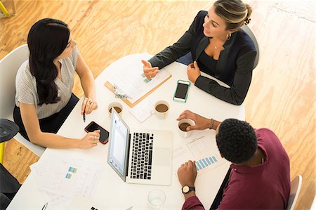 Overhead view of three businesswomen and men meeting at office table Stock Photo - Premium Royalty-Free, Code: 614-09026832