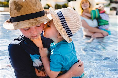 punta cana - Family in outdoor swimming pool, young boy holding younger brother Stock Photo - Premium Royalty-Free, Code: 614-09038634