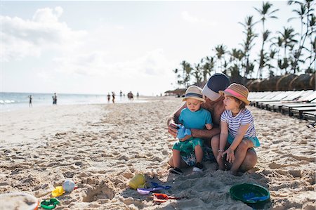 punta cana - Father sitting with young son and daughter on beach Stock Photo - Premium Royalty-Free, Code: 614-09038643