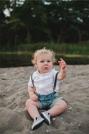 Portrait of male toddler sitting on sandy beach, Lake Ontario, Canada Stock Photo - Premium Royalty-Free, Code: 614-09038693