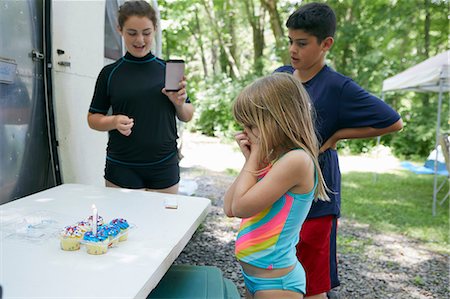 simsearch:614-06442909,k - Three children standing beside table with cakes on, candle in cake, younger girl looking surprised Stock Photo - Premium Royalty-Free, Code: 614-09038785