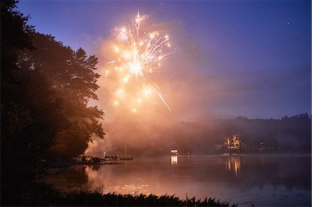 exploding (ignited explosion) - Fireworks exploding over lake at dusk Stock Photo - Premium Royalty-Free, Code: 614-09038799