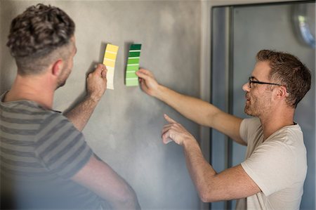 Two men holding colour swatches against bare wall Stock Photo - Premium Royalty-Free, Code: 614-09056516