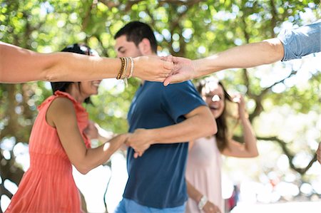 simsearch:614-08383690,k - Adult friends holding hands and dancing together at beach party Foto de stock - Sin royalties Premium, Código: 614-09056547