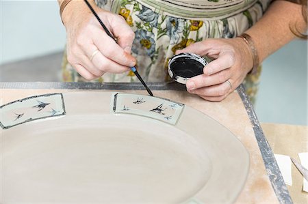 Potter painting motifs on platter Stock Photo - Premium Royalty-Free, Code: 614-09056678