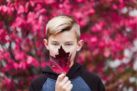 simsearch:614-09056681,k - Portrait of boy holding leaf over mouth Fotografie stock - Premium Royalty-Free, Codice: 614-09056686