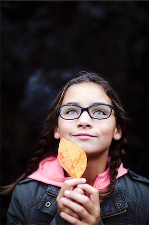 simsearch:614-09056681,k - Portrait of girl with plaits and glasses holding leaf Fotografie stock - Premium Royalty-Free, Codice: 614-09056683
