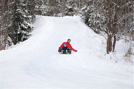 simsearch:649-08577755,k - Man and son tobogganing down hill in snow covered forest Foto de stock - Royalty Free Premium, Número: 614-09056732