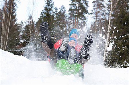 simsearch:614-09245239,k - Man and son on speeding toboggan in snow covered forest Foto de stock - Sin royalties Premium, Código: 614-09056733