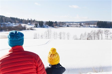 family with back looking out - Rear view of man and son looking out over snow covered landscape Stock Photo - Premium Royalty-Free, Code: 614-09056745