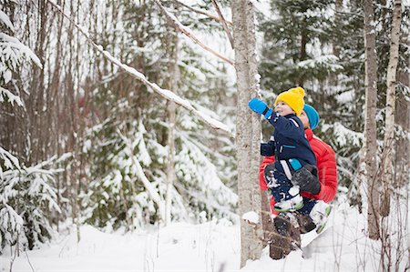 simsearch:614-08982907,k - Man helping son climb tree in snow covered forest Fotografie stock - Premium Royalty-Free, Codice: 614-09056759