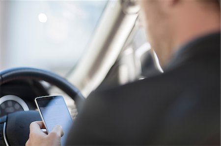 simsearch:614-08877313,k - Businessman sitting in car, looking at smartphone, rear view Stock Photo - Premium Royalty-Free, Code: 614-09056807