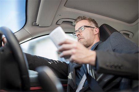 simsearch:614-06044348,k - Businessman driving car, holding smartphone, low angle view Foto de stock - Sin royalties Premium, Código: 614-09056809