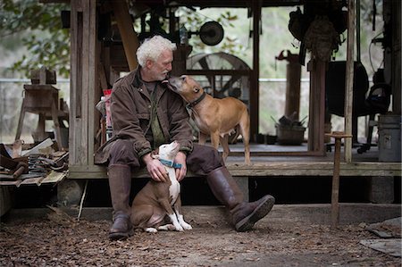 simsearch:649-07437708,k - Man with pet dogs by wooden work hut Photographie de stock - Premium Libres de Droits, Code: 614-09056929