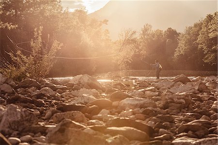 ríos - Fisherman casting fishing line in sunlit river, Mozirje, Brezovica, Slovenia Foto de stock - Sin royalties Premium, Código: 614-09057014