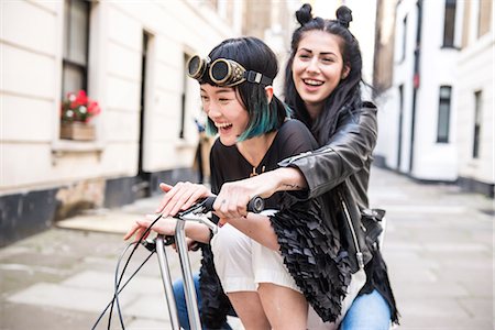 simsearch:649-06401137,k - Two young stylish women cycling retro bicycle along street Stock Photo - Premium Royalty-Free, Code: 614-09057090