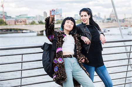 femelle uniquement - Two young stylish women taking smartphone selfie on millennium footbridge, London, UK Stock Photo - Premium Royalty-Free, Code: 614-09057124