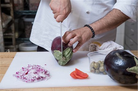 simsearch:649-08766085,k - Cropped view of chef slicing aubergine Photographie de stock - Premium Libres de Droits, Code: 614-09057167