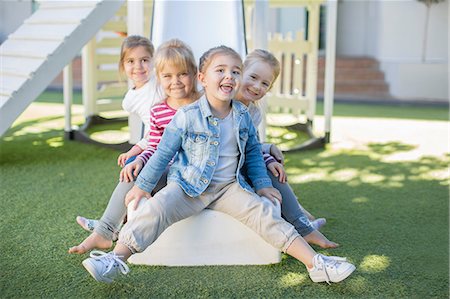 simsearch:614-09057250,k - Girls and boys at preschool, portrait sitting on playground slide in garden Fotografie stock - Premium Royalty-Free, Codice: 614-09057241