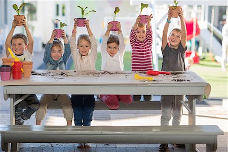 simsearch:614-05523144,k - Girls and boys at preschool, portrait holding up pot plants at picnic table Stock Photo - Premium Royalty-Free, Code: 614-09057243