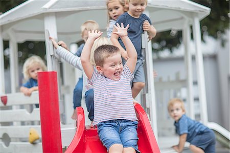 simsearch:614-09057250,k - Boys and girls at preschool, sliding on playground slide in garden Fotografie stock - Premium Royalty-Free, Codice: 614-09057264