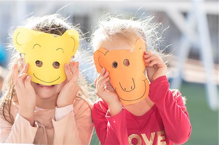 Portrait if two children wearing paper masks Stock Photo - Premium Royalty-Free, Code: 614-09057321