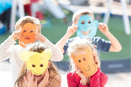 Portrait if four children wearing paper masks Stock Photo - Premium Royalty-Free, Code: 614-09057322