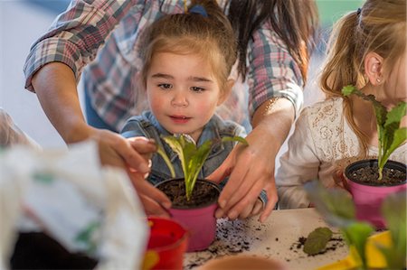 Mid adult woman helping young children with gardening activity Stock Photo - Premium Royalty-Free, Code: 614-09057337