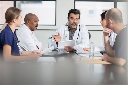 female physician talks to teen - Group of doctors sitting at table, having discussion Stock Photo - Premium Royalty-Free, Code: 614-09057366