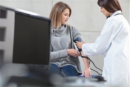 Female doctor taking patients blood pressure Stock Photo - Premium Royalty-Free, Code: 614-09057361