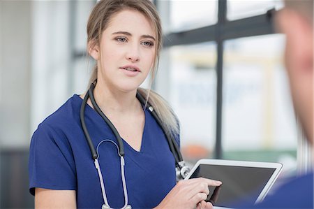 Male and female doctor having discussion, female doctor using digital tablet Stock Photo - Premium Royalty-Free, Code: 614-09057363