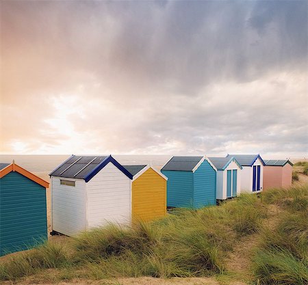 sunny day beach - Row of colourful beach huts and storm clouds over sea, Southwold, Suffolk, England Stock Photo - Premium Royalty-Free, Code: 614-09057426