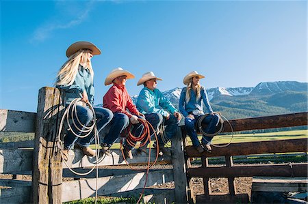 Cowboys and cowgirls on fence, looking away, Enterprise, Oregon, United States, North America Stock Photo - Premium Royalty-Free, Code: 614-09057504